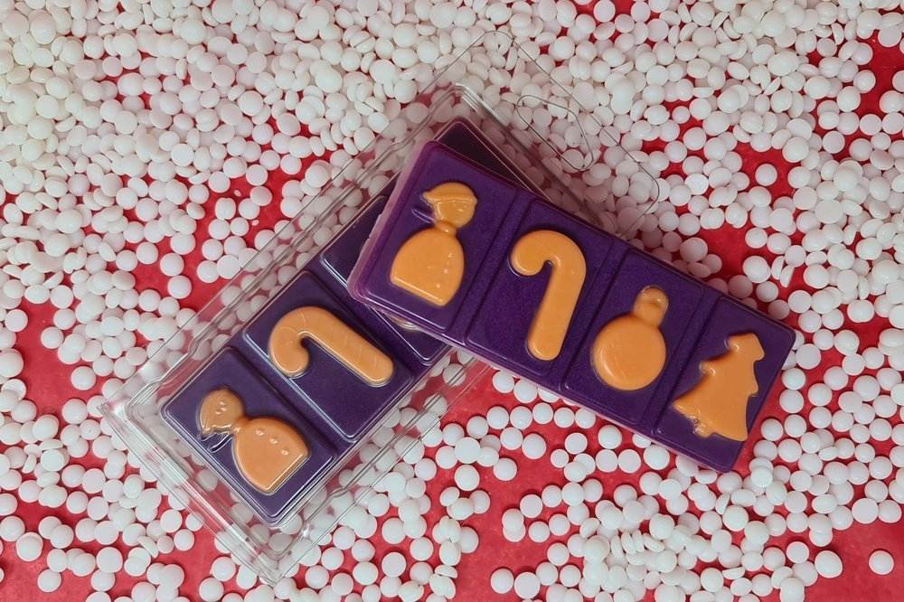 Mulled Wine Wax Melt Snap Bar with festive shapes on a background of white pellets.