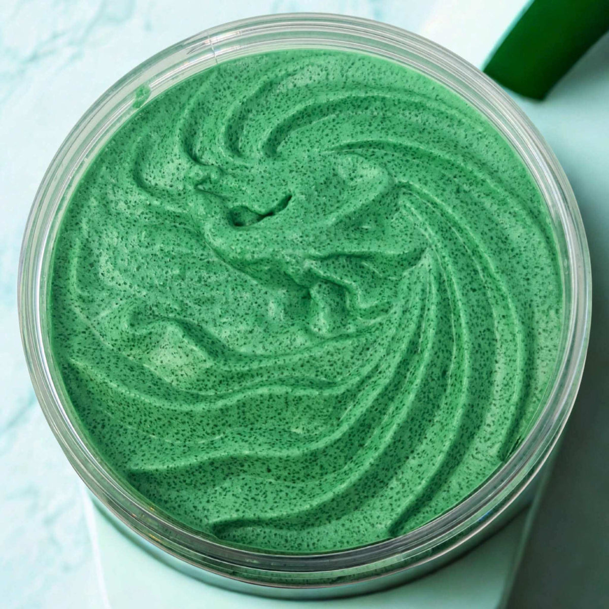 Pear and Freesia Sugar Body Scrub in a clear round container showing vibrant green whipped texture with fine exfoliating sugar granules