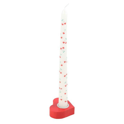 Red heart taper candle holder with a white candle.