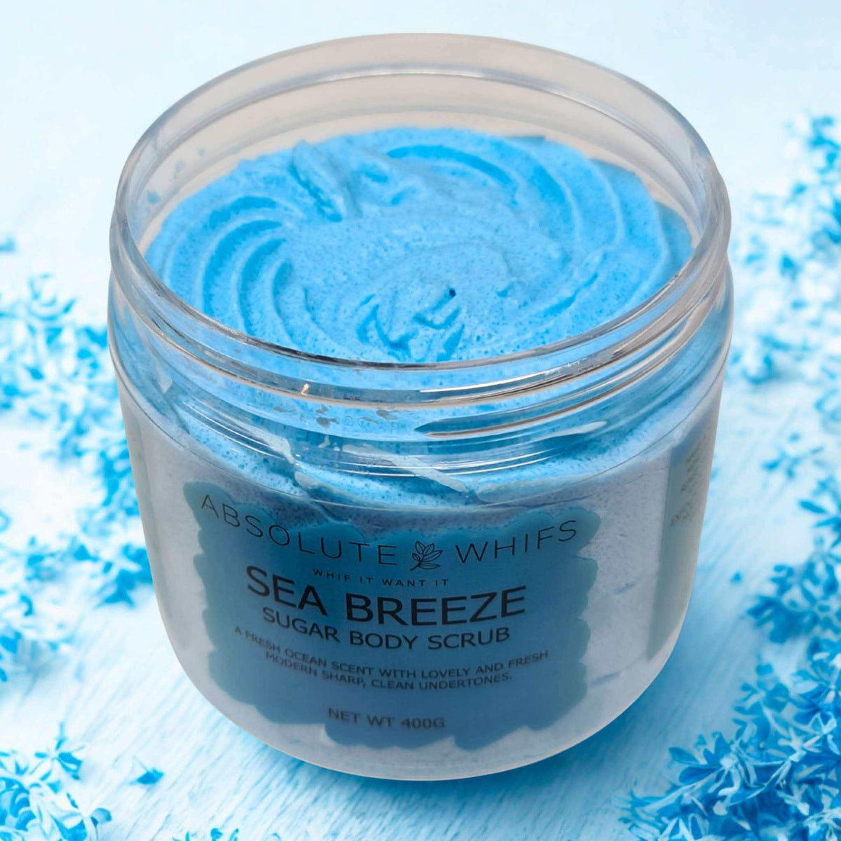 Sea Breeze Sugar Body Scrub in clear jar with vibrant blue whipped texture and smooth swirls inside
