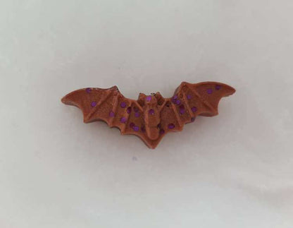 Brown bat-shaped wax melt with purple glitter for Halloween ambiance.