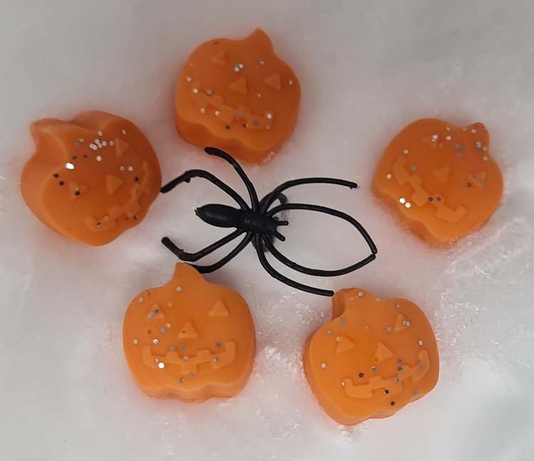 Pumpkin-shaped wax melts with a pumpkin spice fragrance and decorative spider.