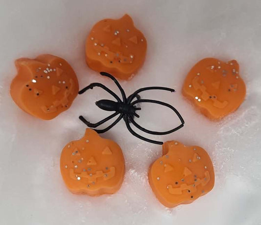 Pumpkin-shaped wax melts with a pumpkin spice fragrance and decorative spider.