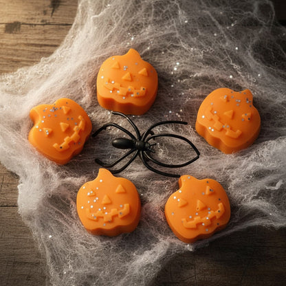 Absolute Whifs pumpkin shaped wax melts with glitter on a spooky spider web background with a plastic spider
