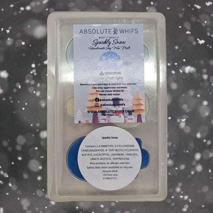Snowmen scented wax melts packaging with Sparkly Snow fragrance against a snowy background.