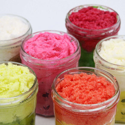 Fragranced sugar body scrub jars in vibrant colors including watermelon daquiri scent, 300g each.